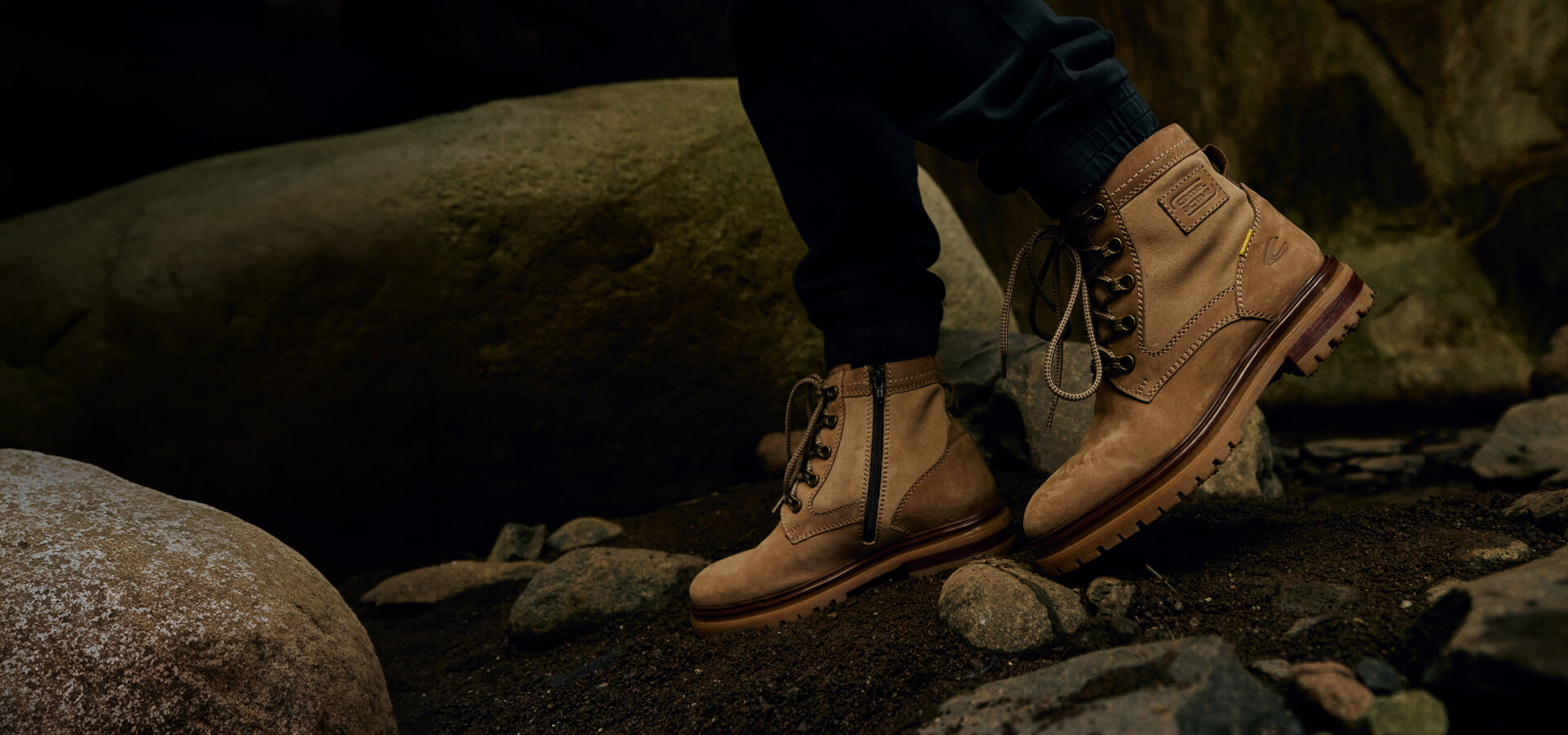 camel active - Flatlay - CAMEL ACTIVE BOOTS: DIE RICHTIGEN BEGLEITER FÜR JEDES ABENTEUER - Eine Person mit Boots wandert auf Steinen